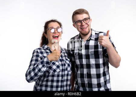 Nerds, geek, bespectacled and funny people concept - a couple of nerds in glasses show us thumbs up on white background Stock Photo