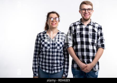 Nerds, geek, bespectacled and funny people concept - funny couple in glasses are hugging on white background Stock Photo