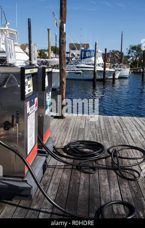 Two fuel pumps on an old wooden dock with different types of boats in the background. This photo is availble for commercial use provided that any trad