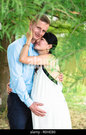 Mans and womens arm show heart on stomach of pregnant woman Stock Photo