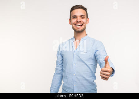 Gesture and people concept - Handsome man with smile showing thumb up on white background with copy space Stock Photo