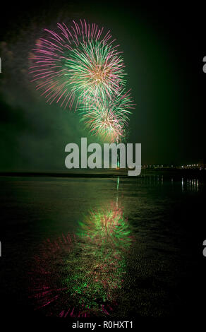 Musselburgh, Scotland, UK, 5th Nov. 2018. Guy Fawkes fireworks reflected in wet sand. Unusually mild 9 degrees for the East Lothian town's free annual fireworks display which was attended by even more people due to the closure of Edinburgh's Meadowbank Stadium. Stock Photo