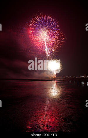 Musselburgh, Scotland, UK, 5th Nov. 2018. Guy Fawkes fireworks reflected in wet sand. Unusually mild 9 degrees for the East Lothian town's free annual fireworks display which was attended by even more people due to the closure of Edinburgh's Meadowbank Stadium. Stock Photo