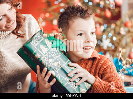 Christmas, happy family, son and mother, unwrapping presents  Stock Photo
