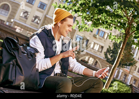 Young stylish tourist blogger is having videocall on the bench. Close-up Stock Photo