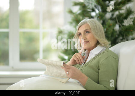 Portrait of a senior woman decorating Christmas tree Stock Photo
