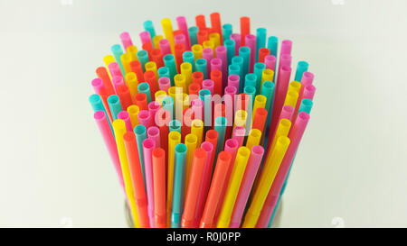 Colorful plastic drinking straws held together against a neutral background. One use, made of plastic straws, number one reason of oceans pollution Stock Photo
