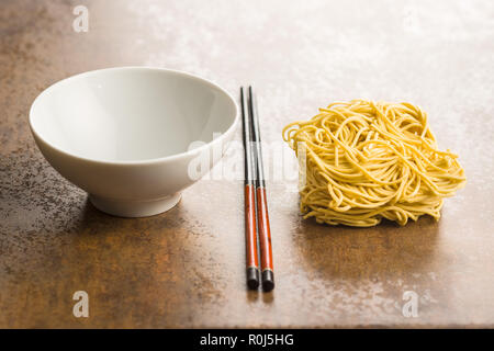 Uncooked instant chinese noodles and chopsticks. Stock Photo