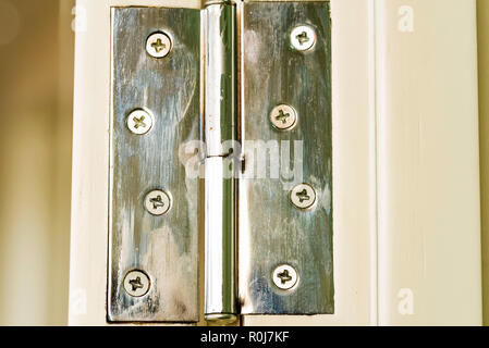 Stainless door hinge on white door close Stock Photo