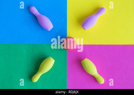 Flat lay of rubber ball with bowling pins toy on colorful background minimal creative concept. Stock Photo