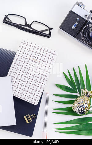 Top view flat lay office workspace desk styled design office supplies tropical palm leaves retro camera copy space black white background. Template of Stock Photo
