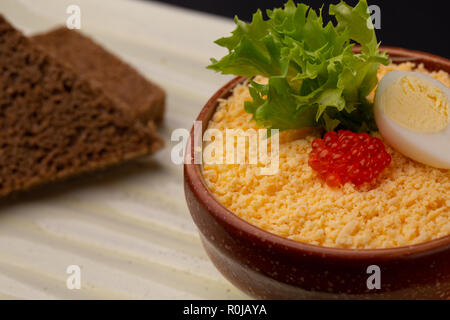 Breakfast with dish from soft-boiled egg with red caviar, served with black bread Stock Photo