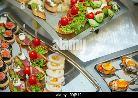 Catering table set service various snacks on a table at banquet. Set of cold snacks, canape, beverages, closeup. Side view. Banquet table Stock Photo
