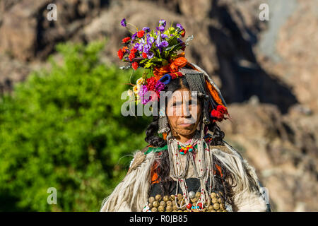 A woman of the Brokpa tribe, an arien race, who migrated to India from Persia, is wearing her traditional dress. The main feature is a flower arrangem Stock Photo