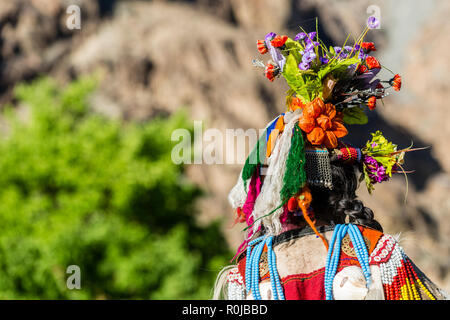 A woman of the Brokpa tribe, an arien race, who migrated to India from Persia, is wearing her traditional dress. The main feature is a flower arrangem Stock Photo