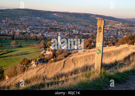 Cotswold way sign on Selsley common looking across to Selsley village in the autumn at sunset. Selsley, Cotswolds, Gloucestershire, UK Stock Photo