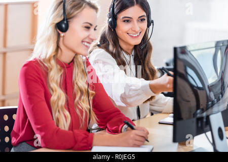 smiling female call center operators working at workplace in office Stock Photo