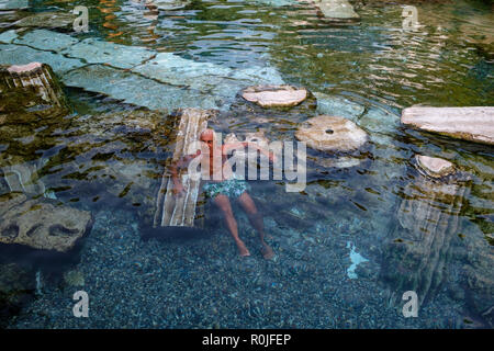 Man relaxing in the sacred pool of Cleopatra at the ruins of the ancient Roman city of Hierapolis, Antalya, Turkey Stock Photo