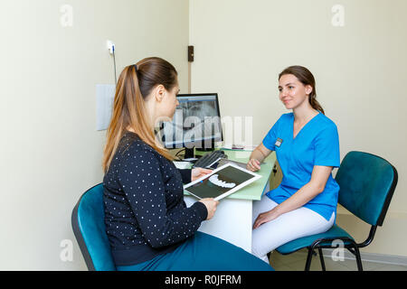 Young woman Dentists and woman patient discussing the x-ray photograph on computer treatment discussion in the office Stock Photo