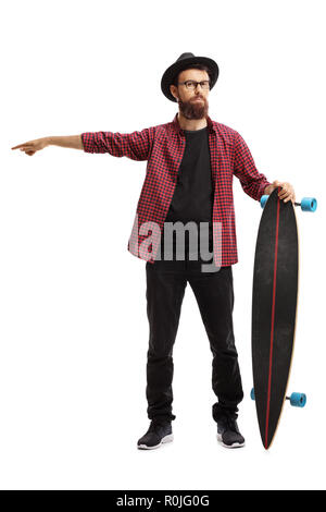 Full length portrait of a male hipster holding a longboard and pointing in one direction isolated on white background Stock Photo