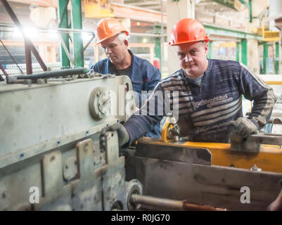 Tyumen, Russia - August 13, 2013: Block making department at construction material factory ZHBI-5. Workers set up machine in shop on production of ste Stock Photo
