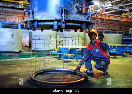 Tyumen, Russia - August 13, 2013: Circle pit making department at construction material factory ZHBI-5. Concrete Goods Plant No. 5. Worker controls pr Stock Photo