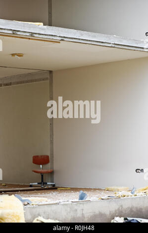 Office chair inside partially demolished building. Stock Photo