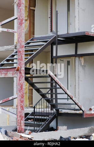 Metallic staircase in front of partially demolished house. Stock Photo