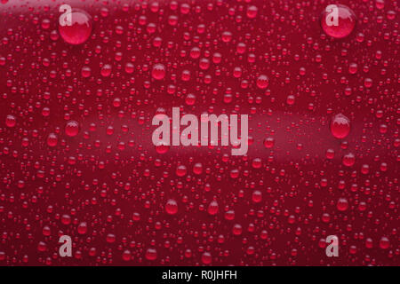 Closeup waterdrops on red ceramic coated paint surface, shallow focus Stock Photo