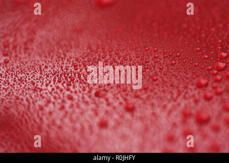 Closeup waterdrops on red ceramic coated paint surface, shallow focus Stock Photo