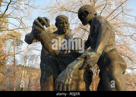 Timeline of the rising sun during the winter dusk sky viewed from behind the Bronze sculpture in the military cemetery Reimsbach an der Saar, Germany. Stock Photo