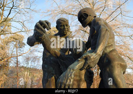 Timeline of the rising sun during the winter dusk sky viewed from behind the Bronze sculpture in the military cemetery Reimsbach an der Saar, Germany. Stock Photo