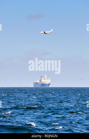 Airplane flying above a cruising ship, transport and logistics concept, authentic picture. Stock Photo