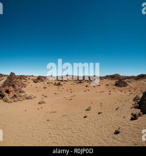 desert landscape with volcanic rocks and blue sky Stock Photo