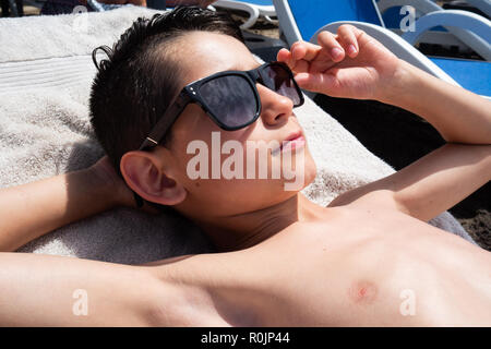 Young boy wearing fashion sunglasses on the beach Stock Photo