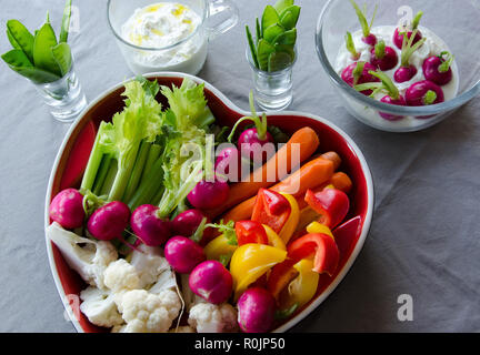 Vegetables in a heartshaped tray ready to eat on light background. Stock Photo