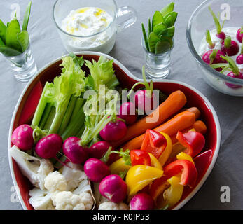 Vegetables in a heartshaped tray ready to eat on light background. Stock Photo