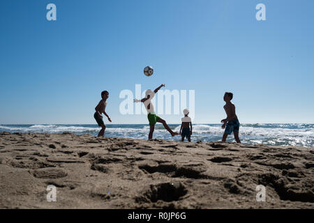 Kids playing football on the beach in Marbella, Spain Stock Photo