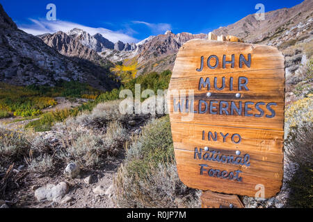 Sign posted at the entrance to the John Muir Wilderness, in the Inyo National Forest; Eastern Sierra mountains, California; McGee valley visible in th Stock Photo