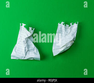 wrinkled white sheet torn from a notepad on a green background Stock Photo