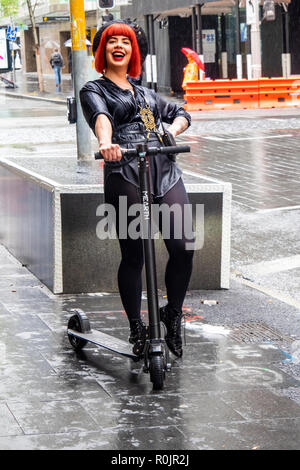 Flame haired concierge of QT Hotel on a kick scooter Sydney NSW Australia. Stock Photo