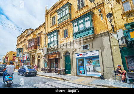 VICTORIA, MALTA - JUNE 15, 2018: The line of old edifices along the busy road in Independence square, on June 15 in Victoria. Stock Photo