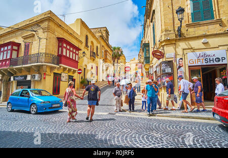 VICTORIA, MALTA - JUNE 15, 2018: The narrow street with small edifices, stores and cafes leads to the medieval Cittadella of Rabat - the fortress, loc Stock Photo