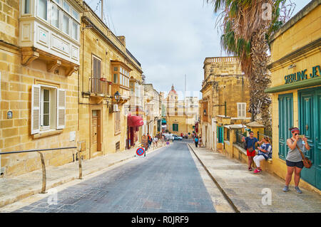 VICTORIA, MALTA - JUNE 15, 2018: The hilly street with historic housing stretches between the Independence square in lower town and Cittadella (Fortre Stock Photo