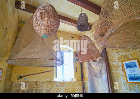 VICTORIA, MALTA - JUNE 15, 2018: The chamber of Folklore Museum (Gran Castello Historic House) with different shaped fishing nets, hanging fro the cei Stock Photo