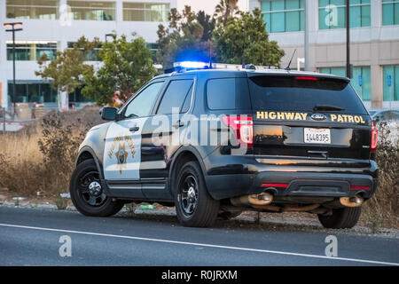 September 21, 2018 Santa Clara / CA / USA - Highway Patrol car stopped on the side of the freeway in the evening Stock Photo