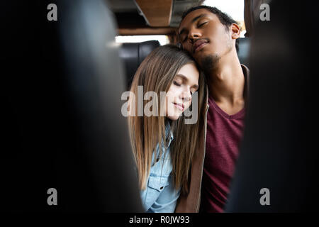 selective focus of young interracial couple sleeping during trip on travel bus Stock Photo