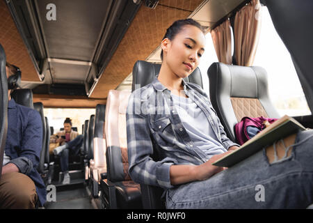 low angle view of asian female traveler reading book during trip on travel bus Stock Photo