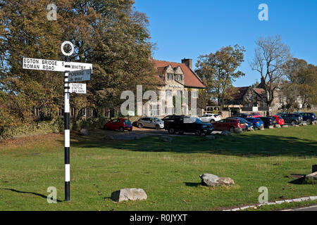 Signpost road sign outside the Mallyan Spout Hotel in autumn Goathland village North Yorkshire England UK United Kingdom GB Great Britain Stock Photo