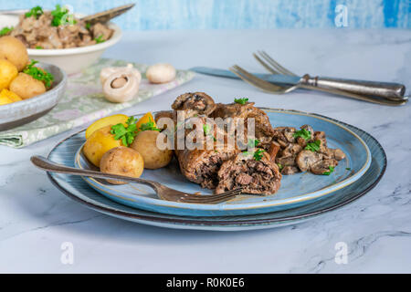 Beef roulade staffed with mushrooms in creamy mushroom sauce served with boiled baby potatoes Stock Photo